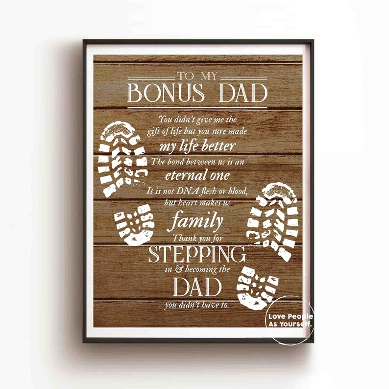Puede incluir: Un fondo de madera con texto blanco que dice "To My Bonus Dad". El texto contin&uacute;a con un mensaje sobre el v&iacute;nculo entre un padrastro y un hijo. El fondo est&aacute; decorado con huellas blancas.