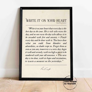 May include: A black framed print with a white background featuring a quote by Ralph Waldo Emerson. The quote reads "Write it on your heart that every day is the best day in the year. He is rich who owns the day, and no one owns the day who allows it to be invaded with fret and anxiety. Finish every day and be done with it. You have done what you could. Some blunders and absurdities, no doubt crept in. Forget them as soon as you can, tomorrow is a new day; begin it well and serenely, with too high a spirit to be cumbered with your old nonsense. This new day is too dear, with its hopes and invitations, to waste a moment on the yesterdays." The quote is followed by a handwritten signature. The bottom of the print reads "Love People As Yourself."