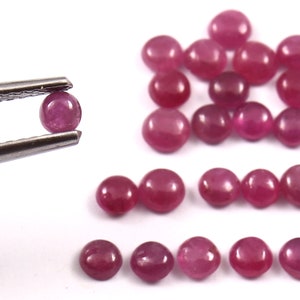 Peut inclure: Une collection de 20 pierres précieuses de rubis rondes taillées en cabochon. Les pierres sont d'une couleur rouge foncé et ont une finition lisse et polie. Les pierres mesurent environ 4 mm de diamètre.