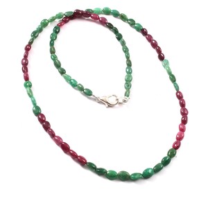 Op de afbeelding: Een groene en roze edelsteen ketting met een zilveren sluiting. De ketting is gemaakt van ovale kralen.