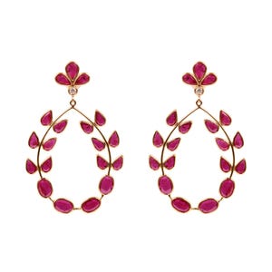 May include: A pair of gold-toned earrings featuring a floral design with ruby-colored gemstones. The earrings have a teardrop shape with a small diamond accent at the top. The gemstones are oval and teardrop-shaped.