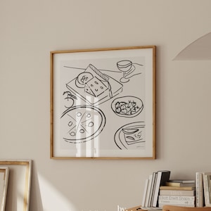 May include: A black and white line drawing of a still life featuring a plate of pizza, a plate of strawberries, a plate of cheese, and a glass of wine. The drawing is framed in a light wood frame.