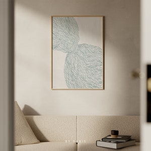 May include: Abstract art print with a light green, organic shape on a white background. The print is framed in a light wood frame.