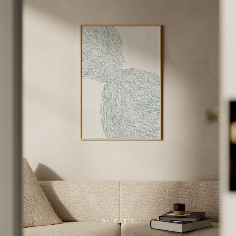 May include: Abstract art print with a light green, organic shape on a white background. The print is framed in a light wood frame.