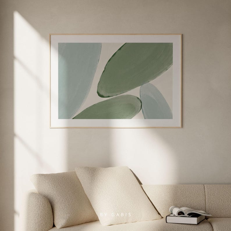 May include: Abstract art print featuring a framed image of overlapping green and blue shapes. The print has a white background and a wooden frame.