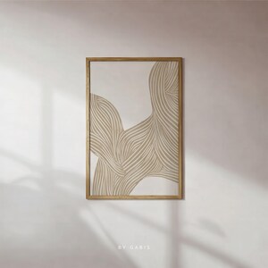 May include: A rectangular framed wall art piece featuring a beige and off-white abstract design of flowing, curved lines. The artwork is enclosed in a light-toned wooden frame. The text BY GABIS is printed in small white letters at the bottom center.