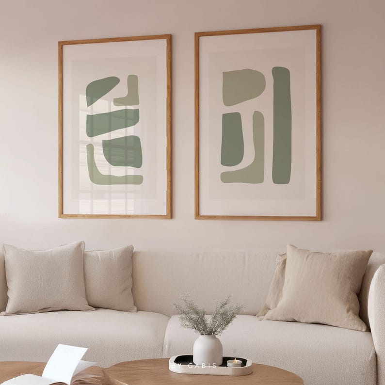 May include: Two framed abstract art prints with a minimalist design featuring geometric shapes in shades of green on a white background.