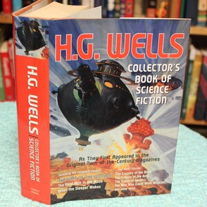 May include: A hardcover book titled "H.G. Wells Collector's Book of Science Fiction." The cover features a retro illustration of a black airship with a futuristic design, set against a blue background. The book includes several novels and short stories.