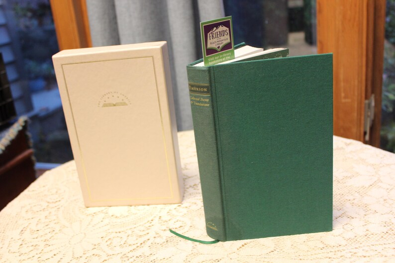 May include: A green hardcover book with a white slipcover. The book is titled "The Collected Poetry of Theodore Roethke" and has a bookmark with the word "FRIENDS" on it.