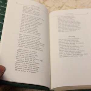May include: An open book with green pages and white text. The text is a poem about nature, with lines like "Maple sap, and delicate bells, Green with green the day was bright."
