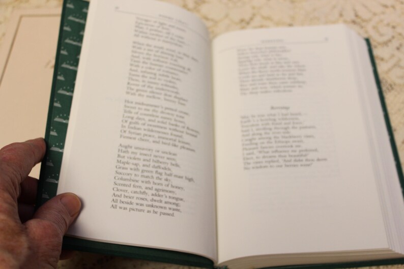 May include: An open book with green pages and white text. The text is a poem about nature, with lines like "Maple sap, and delicate bells, Green with green the day was bright."