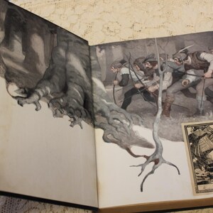 May include: Open book with a black and white illustration of a forest scene with figures in the background. The book is open to a page with a black and white illustration of a ship with the text "My Book" on the page.
