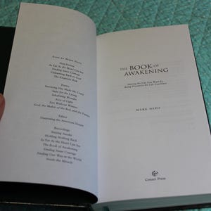 Może przedstawiać: Otwarta książka zatytułowana "The Book of Awakening" autorstwa Marka Nepo. Strony książki są białe z czarnym tekstem. Lewa strona zawiera spis treści. Prawa strona wyświetla tytuł i nazwisko autora.