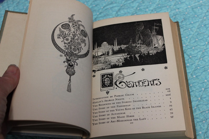 May include: Open book with illustrations and text. The left page features a black and white floral design. The right page displays a black and white illustration of a city and the word "Contents". The book is open to the table of contents.