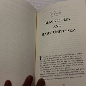 May include: A book titled "Black Holes and Baby Universes" with the text "Falling into a black hole has become one of the horrors of science fiction. In fact, black holes can now be said to be really matters of science fact rather than science fiction."