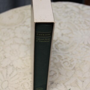 May include: A green hardcover book with the title "EMERSON Collected Poems & Translations" on the spine.