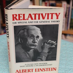May include: A hardcover book titled Relativity: The Special and the General Theory by Albert Einstein. The white dust jacket features a black and white portrait of Albert Einstein with his hands clasped, and the text A Clear Explanation That Anyone Can Understand.