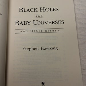 May include: A book titled "Black Holes and Baby Universes and Other Essays" by Stephen Hawking. The book cover is white with black text and a small black logo at the bottom.
