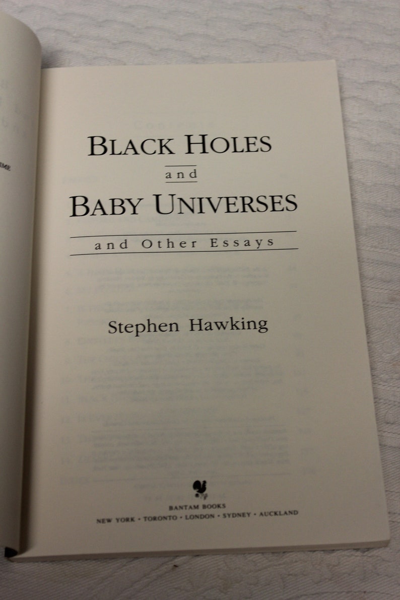 May include: A book titled "Black Holes and Baby Universes and Other Essays" by Stephen Hawking. The book cover is white with black text and a small black logo at the bottom.