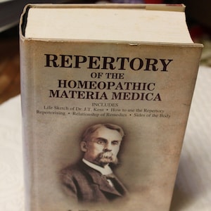May include: A book titled "Repertory of the Homeopathic Materia Medica" by J.T. Kent. The book cover features a portrait of J.T. Kent and includes information about the book's contents.