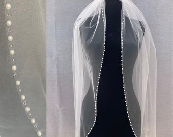 May include: A white bridal veil with a pearl trim. The veil is made of soft tulle and has a delicate, flowing design.
