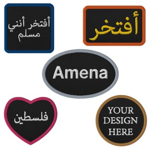 May include: Five embroidered patches with different shapes, colours, and text. The patches include a square patch with blue trim and white text in Arabic, a rectangular patch with orange trim and yellow text in Arabic, an oval patch with grey trim and white text that says "Amena", a heart-shaped patch with pink trim and white text in Arabic, and a round patch with brown trim and white text that says "YOUR DESIGN HERE".