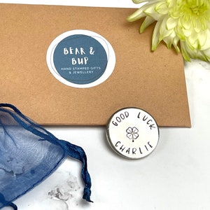 good luck aluminium pocket token with the name Charlie and a four leaf clover stamped on it in black.