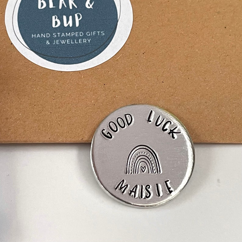 good luck aluminium pocket token with the name Maisie and a rainbow stamped on it.