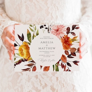 May include: A wedding invitation with a watercolor floral design in shades of orange, yellow, and pink. The invitation reads "Together with their families Amelia & Matthew One Whitehall Place, London Saturday, June 21, 2027 at 2:00 PM Reception to follow"