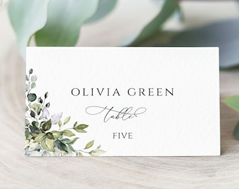 May include: White card with green watercolor floral design and black text. The text reads "Olivia Green Table Five".