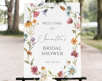 May include: A white sign with a floral wreath border and the text "Welcome to Samantha's Bridal Shower August 27th, 2026". The sign is on a black easel.