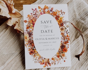 May include: Save the Date card with a floral wreath design in shades of orange, red, and yellow. The text reads "Save the Date" for the wedding of Olivia & Marcus, September 1st, 2027, London, UK.