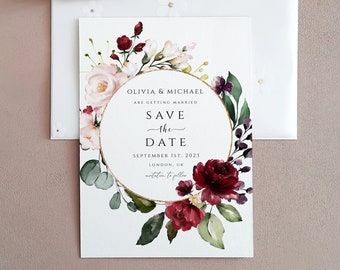 May include: Save the date card with a watercolor floral wreath in shades of pink, red, and green. The text reads "Olivia & Michael are getting married. Save the Date. September 1st, 2023. London, UK. Invitation to follow."