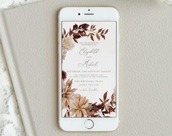 May include: A white smartphone displays a wedding invitation with floral accents. The invitation text reads "Elizabeth and Michael" and includes the date "Saturday, the fifth of August." The phone rests on a light gray book, with a white flower and lace in the background.