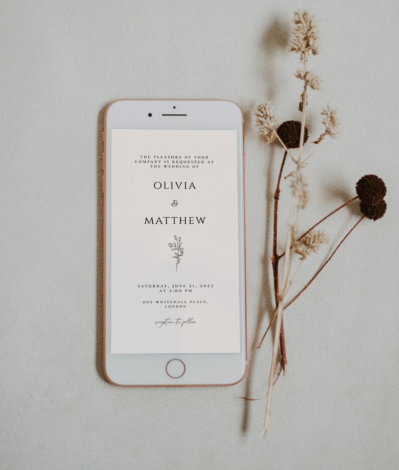 May include: A white smartphone screen displays a wedding invitation for Olivia & Matthew. The invitation includes the date, time, and location of the wedding: Saturday, June 21, 2023 at 2:00 PM, One Whitehall Place, London.