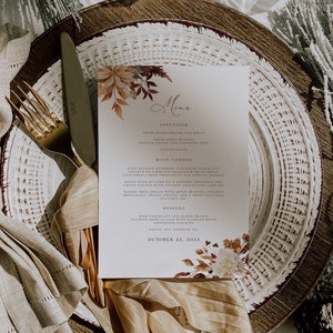 May include: A fall-themed menu with a watercolor illustration of autumn leaves and flowers. The menu lists appetizers, main courses, desserts, and coffee and tea. The date is October 22, 2022.