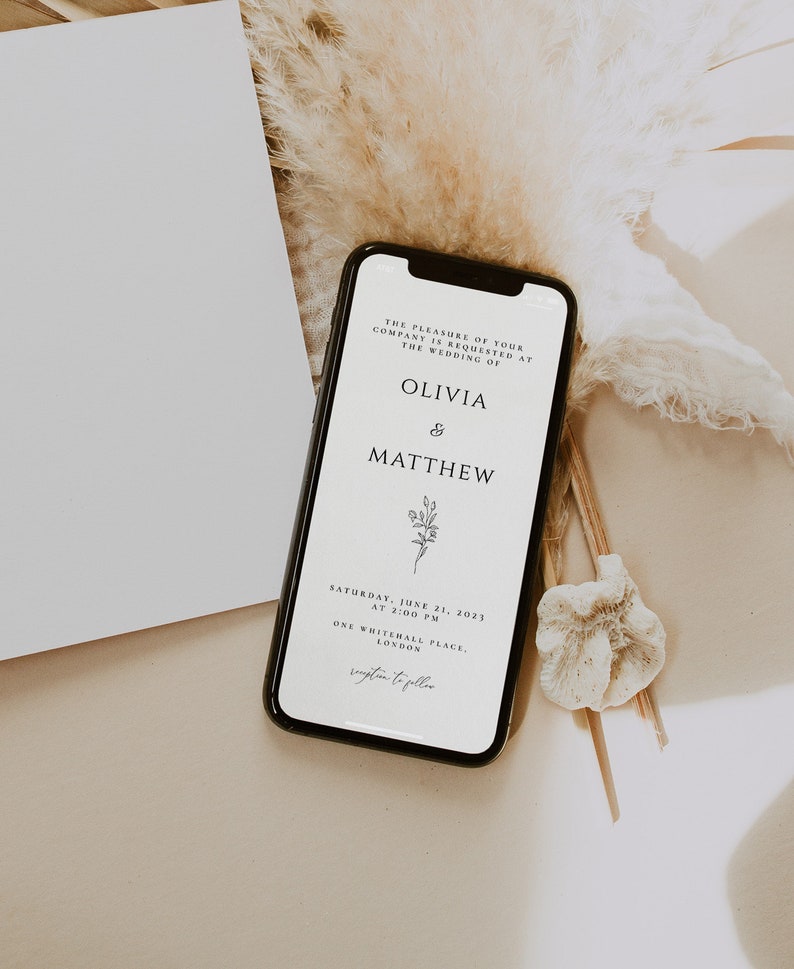 May include: A digital wedding invitation on a smartphone screen. The invitation is for the wedding of Olivia and Matthew, taking place on Saturday, June 21, 2023 at 2:00 PM at One Whitehall Place, London.