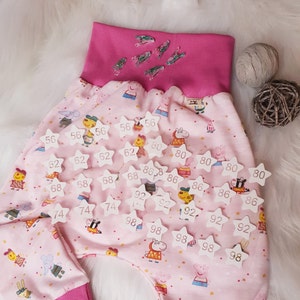 Pode incluir: Cal&ccedil;as de tecido rosa com uma cintura branca e patches em forma de estrela branca com n&uacute;meros neles. Os n&uacute;meros nos patches s&atilde;o 56, 62, 68, 74, 80, 86, 92 e 98.