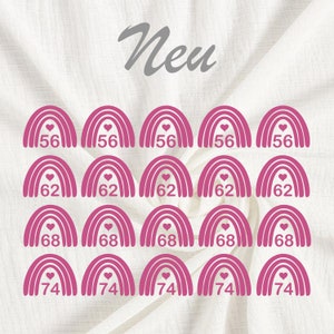 Pode incluir: Um conjunto de vinte patches de arco-&iacute;ris rosa para passar a ferro com um cora&ccedil;&atilde;o no centro. Os patches s&atilde;o numerados 56, 62, 68 e 74.