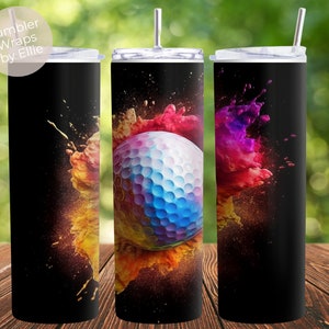 May include: A black tumbler with a colorful paint splatter design and a golf ball in the center. The design features shades of red, orange, yellow, blue, and purple.