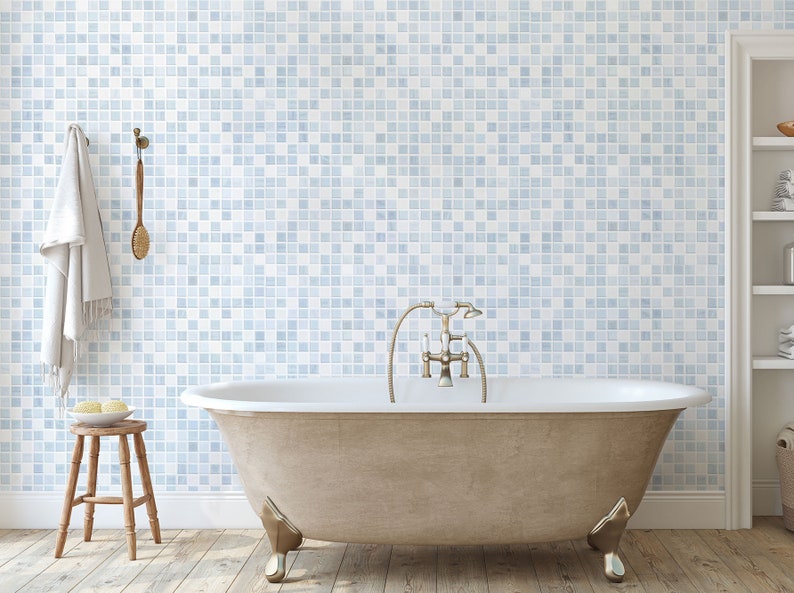 May include: A white freestanding bathtub with a chrome faucet and shower head. The bathtub is in a bathroom with a blue and white tiled wall and a wooden floor.