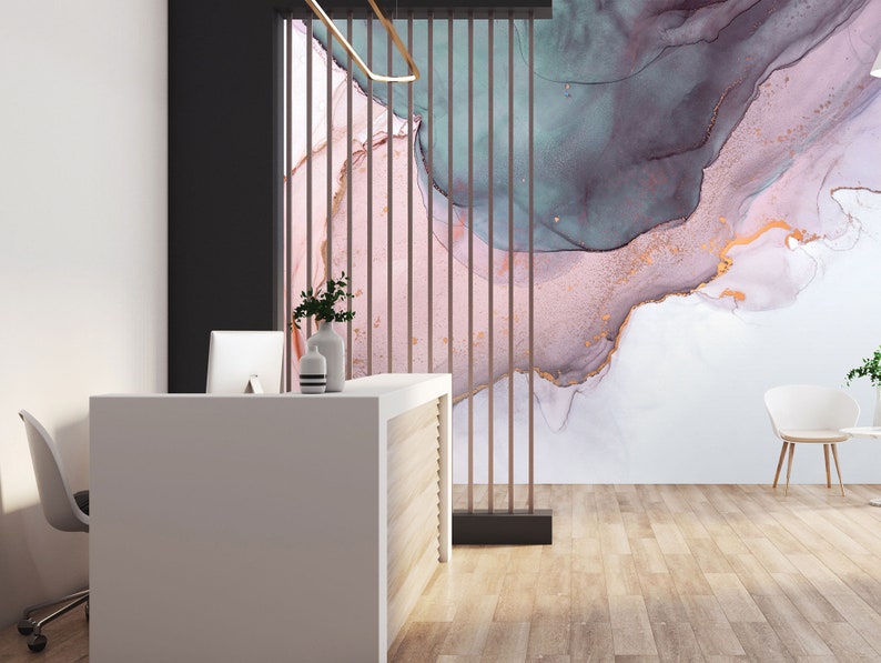 May include: A modern office reception area with a white desk and a chair. The wall behind the desk features a large abstract painting with pink, blue, and gold colours.