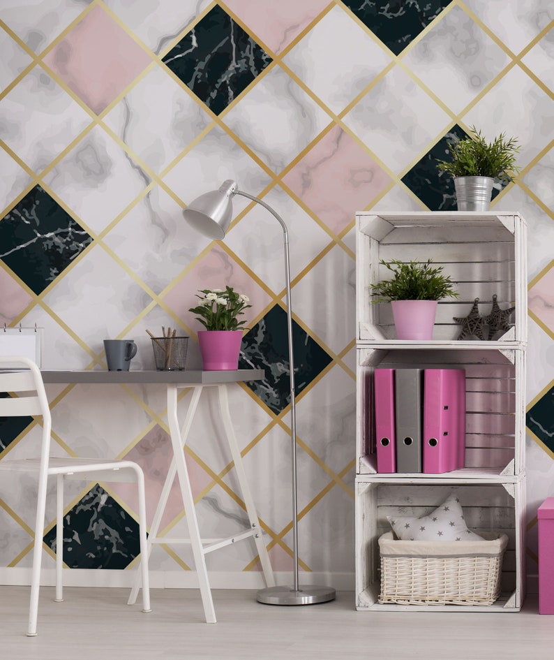 May include: A modern interior with a geometric marble wallpaper design in pink, white, and black, accented with gold lines. A desk, chair, and shelving unit are visible, along with potted plants and office supplies. The room is well-lit with a silver floor lamp.