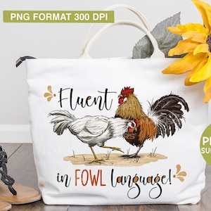 May include: A white tote bag with a graphic of two chickens and the text "Fluent in FOWL language!" printed on it. The bag has brown handles and is sitting on a wooden surface.