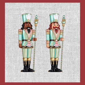 May include: Two nutcracker figurines with gold accents stand against a burlap background. One nutcracker is wearing a teal and gold uniform with a black beard and mustache. The other nutcracker is wearing a teal and gold uniform with a red beard and mustache.