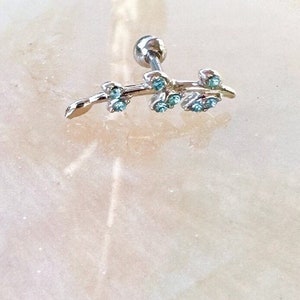 May include: Silver ear cuff with a delicate branch design and blue crystal accents.