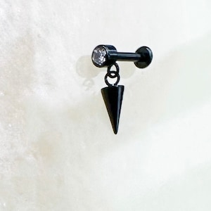 Labret con bisel de cristal colgante con punta negra de titanio de grado implante. 16G. 6 mm u 8 mm. Para perforaciones de cartílago, hélice, trago, plano y lóbulo.