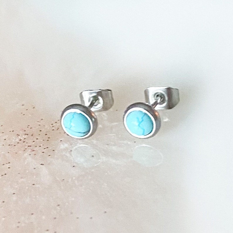 May include: A pair of silver stud earrings with turquoise stones.