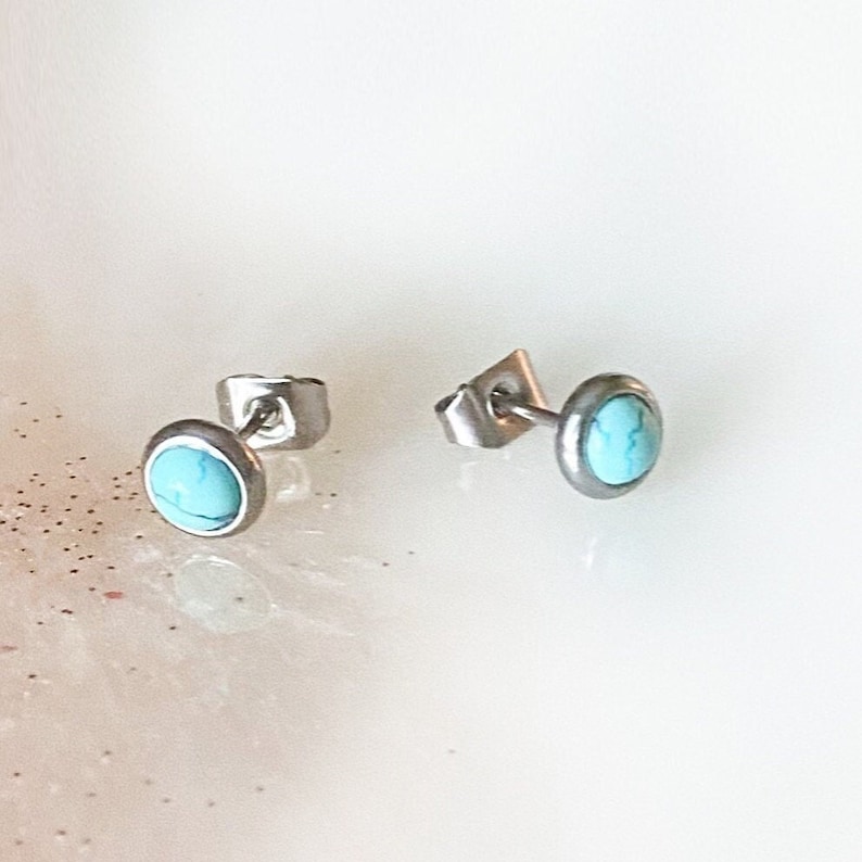 May include: A pair of silver stud earrings with turquoise stones.