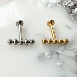Lijnlabret van titaniumkwaliteit met kralen in goud of zilver. 16G of 18G. Voor kraakbeen-, tragus-, schelp-, helix-, platte en lobpiercings.